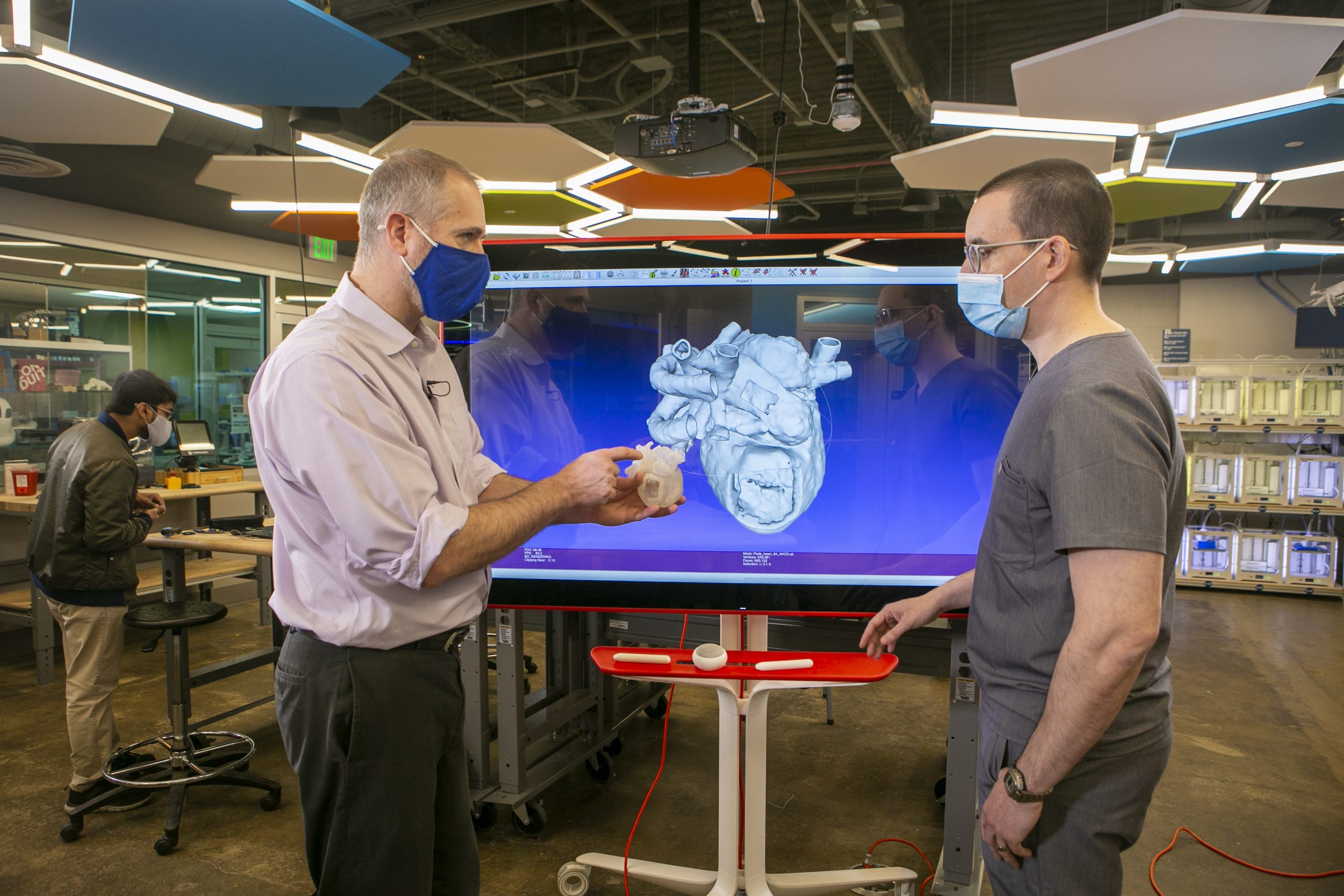 Chip Bobbert, CoLab digital fabrication architect and senior analyst, and Cardiac sonographer Gregory Sturgeon review a 3D model of a patient's heart that Duke's Innovation CoLab will print to help Duke cardiologists prepare for surgery.