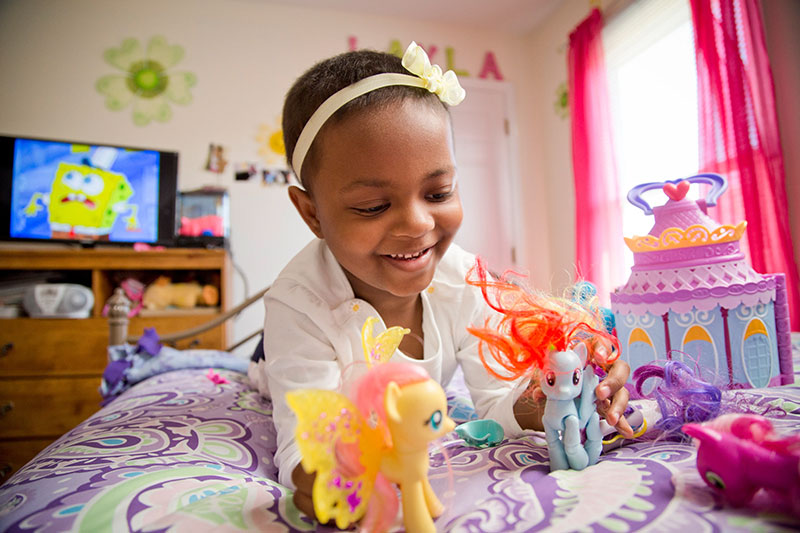Layla Smith, 9, playing with toys in a very colorful room
